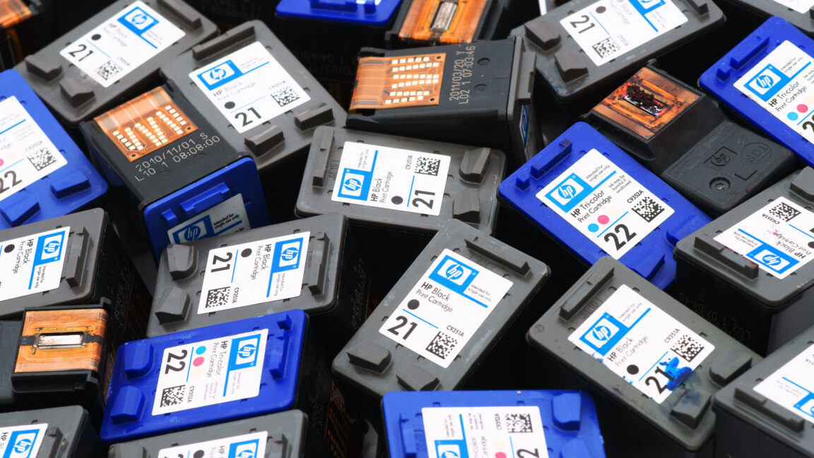 Used Hewlett-Packard black and tri-color printer ink cartridges pile. Some cartridges with visible print heads others with visible label. Cartridges filling entire frame.
